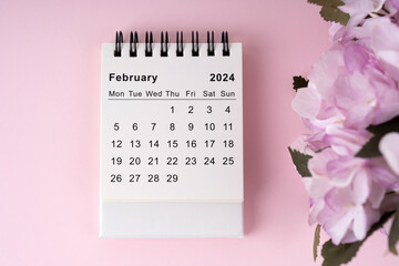 February 2024 desk calendar on pink background flat lay