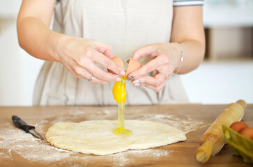 Obraz na płótnie Canvas Crop woman preparing dough at table at home