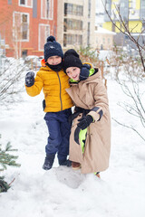 Winter games outdoors. Children walking and playing in warm clothes, winter time