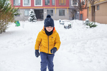 Fototapeta na wymiar Winter games outdoors. Kid boy walking and playing in warm clothes, winter time