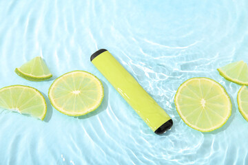 Electronic cigarette with lime in water on blue background