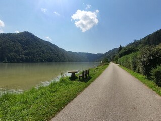 Beautiful bike path at famous Danube River: Donauradweg next to the river on a sunny day with clear blue sky and copy space for text, austria