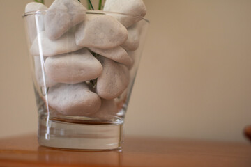 Glass with white rocks inside and some negative space on the right
