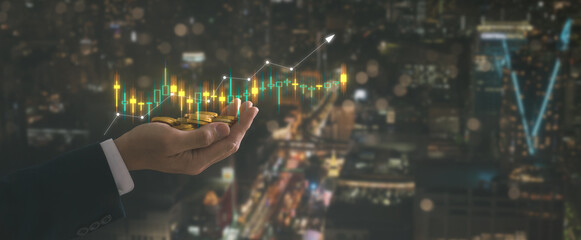 investment and finance concept, businessman holding virtual trading graph and blurred coins on hand with blurred city background, stock market profits and business growth property invest