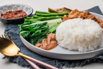 Crispy Pork Kare Kare (Peanut Sauce) with Vegetables and Shrimp Paste on the side 

