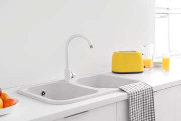 White kitchen counters with sink and yellow toaster