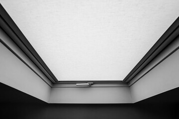 Abstract, monochrome view of a newly fitted skylight window seen in a loft conversion. The textile...