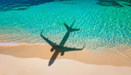 Fototapeta na wymiar The shadow of a plane flying over a beautiful exotic tropical beach