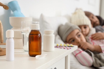 Medications on table of ill family in bedroom, closeup