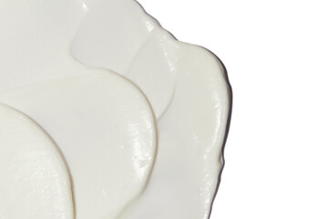 White cosmetic cream smeared on a blank background.