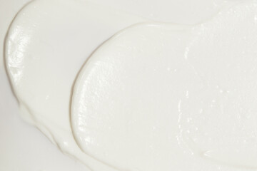 Thick white cosmetic cream applied to the surface. texture of the cream close-up.