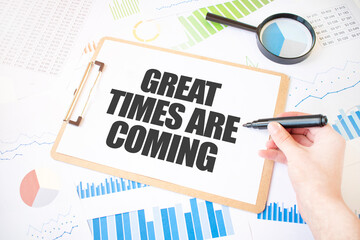 Text GREAT TIMES ARE COMING on white paper sheet and marker on businessman hand on the diagram....