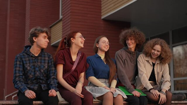 Friends sitting on the parapet near the school