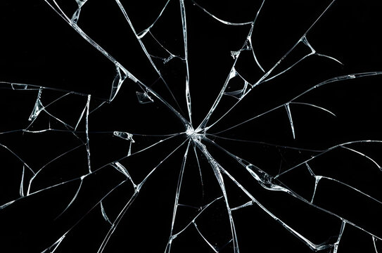 Photo of broken glass on a black background, cracks.