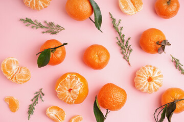 Tasty tangerines with leaves and thuja branches on pink background - Powered by Adobe