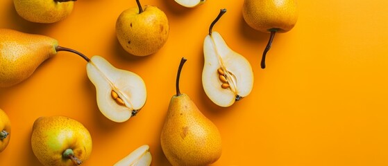 Ultrawide healthy backdrop of ripe pears on an orange background, some sliced to show the inside.