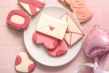 Plate with sweet cookies with gift and balloon on pink tile background. Valentine's Day celebration