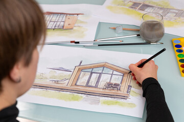 Architect illustrator working on hand drawn illustration of a modular house  using black pencil to...
