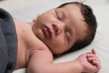 Fototapeta na wymiar Newborn baby in the first days of life. Cute little newborn boy. Close-up