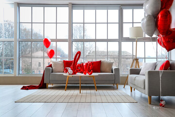 Interior of living room decorated for Valentine's Day with sofas and heart-shaped balloons