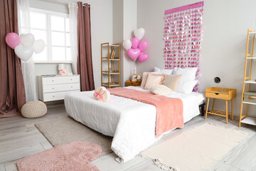 Interior of bedroom decorated for Valentine's Day with hearts and balloons