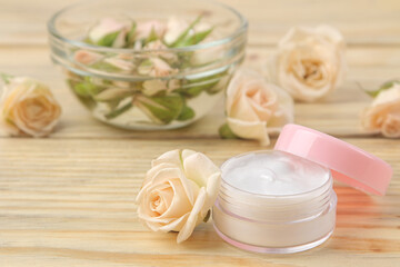 Obraz na płótnie Canvas face and body cream with rose extract on a wooden table, cosmetics for self-care, spa treatments