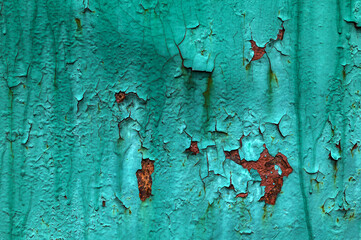 Old green paint on metal with rust.