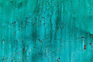 Old green paint on metal with rust.