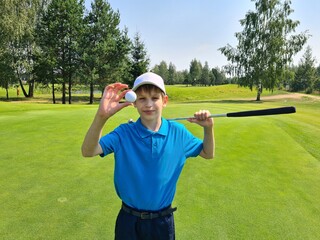 Golfer shows a golf ball and holds a golf club