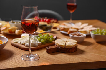 Rose wine and appetizers served on wooden table, selective focus. Space for text