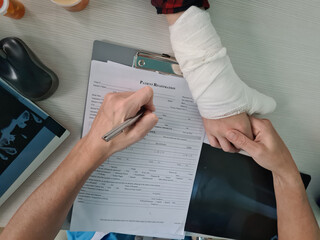 Physiotherapist writes report with patient with wrist fracture in clinic