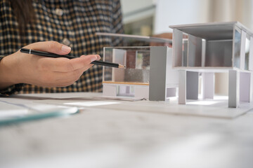 House model on Buleprint construction drawing and drawing equipment stationary Architect analyzing house model house modern in hand Architect Design
