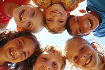 Group of joyful children forming a circle and looking down at the camera, with sunlight filtering through on a bright day