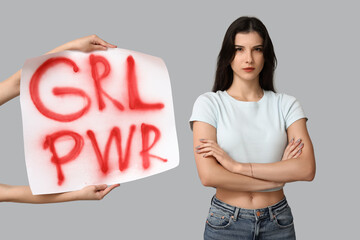 Young woman with crossed arms and sign GRL PWR on grey background. Feminism concept
