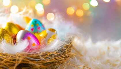 œufs de pâques colorés dans un nid avec plume et fond flou avec espace de copie - obrazy, fototapety, plakaty