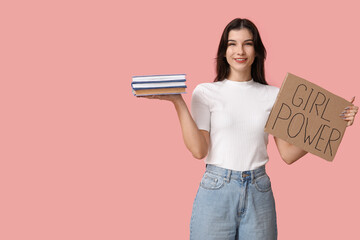 Young woman with sign GIRL POWER and books on pink background. Feminism concept