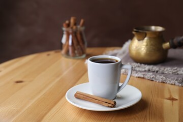 Turkish coffee. Freshly brewed beverage on wooden table, space for text