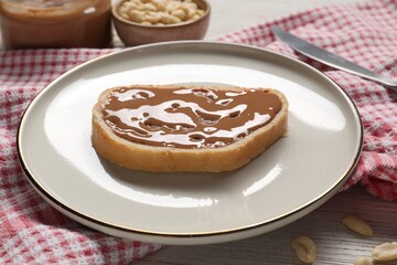 Toast with tasty nut butter on table, closeup