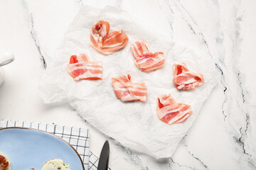 Paper with hearts made of tasty bacon on light background