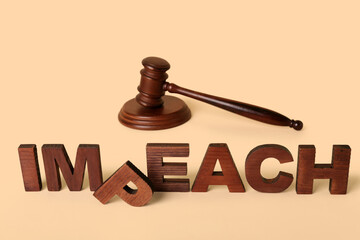 Judge gavel and jumbled word IMPEACH on beige background