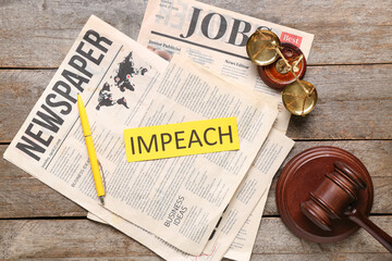 Newspapers with word IMPEACH, judge gavel and scales of justice on wooden table