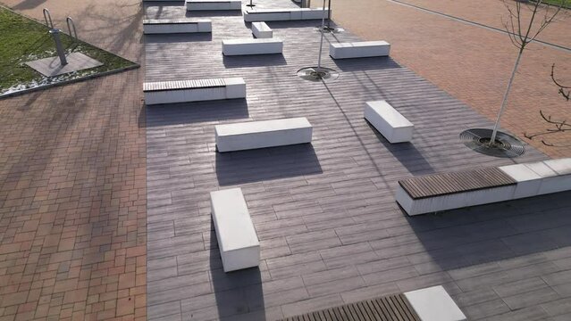concrete white bench block and wave shape in the park on a dark cobbled square, clean concrete surface gray brown white pedestrian and rest area at the skate park for young people, teenagers