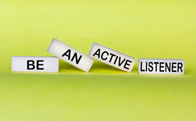 Wooden blocks with the inscription Be an active listener on a yellow background.