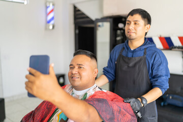 Client using phone to look himself after cutting hair