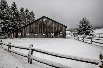 Barn with fence after a heavy snow
