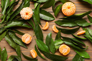Sweet mandarins and leaves on wooden background