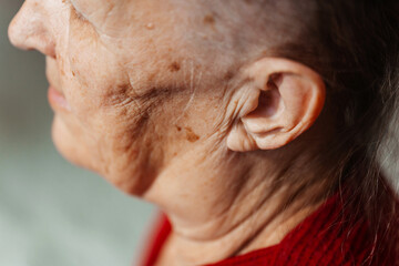 old grandmother's ear. photo of a woman's ear. wrinkled cheeks of an old grandmother - obrazy, fototapety, plakaty