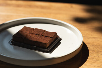 Close-up of a delicious brownie on a ceramic plate, perfect for food-related content.
