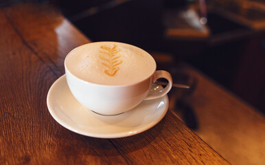 Cappuccino coffee close up in the making above wooden table