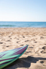 Fototapeta na wymiar Surfboard on the sand by the seaside